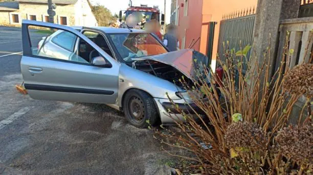 El coche quedó empotrado contra un poste de la luz y un cierre de una vivienda