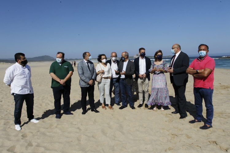 El conselleiro de Sanidade, junto a miembros d ela Corporación Municipal en la playa de A Frouxeira.