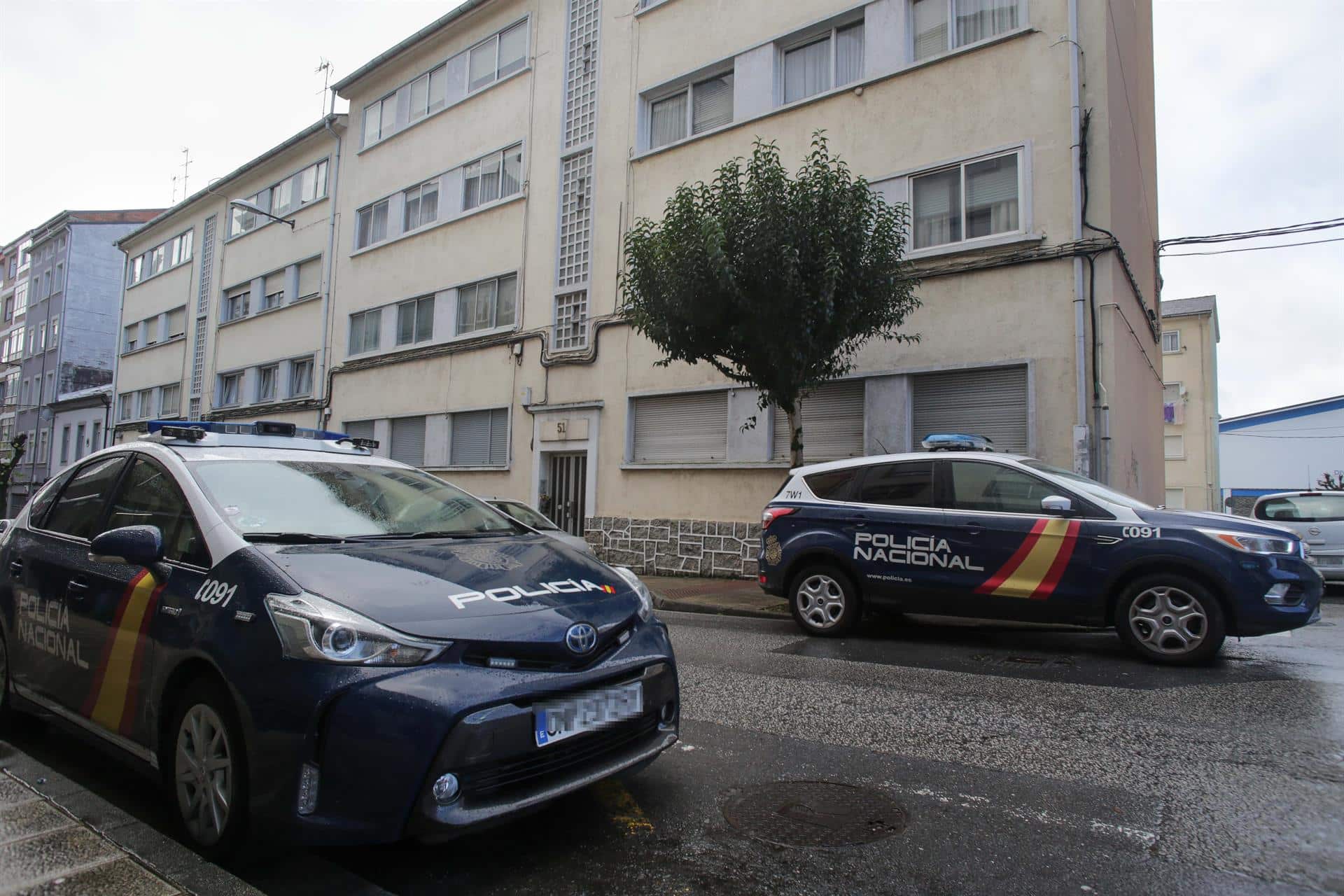 Dos vehículos de Policía Nacional en la puerta de la vivienda donde han hallado muerta a una mujer de 42 años | EP