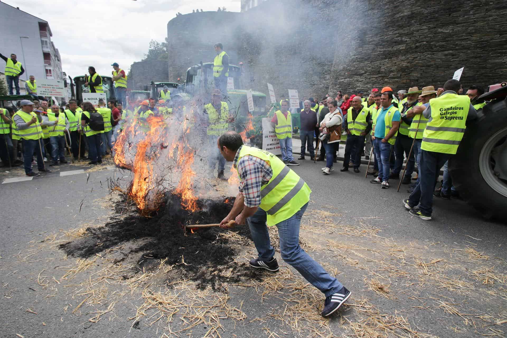 Un ganadero hace una hoguera con paja durante una manifestación en la Muralla de Lugo, a 11 de mayo de 2023 | EP