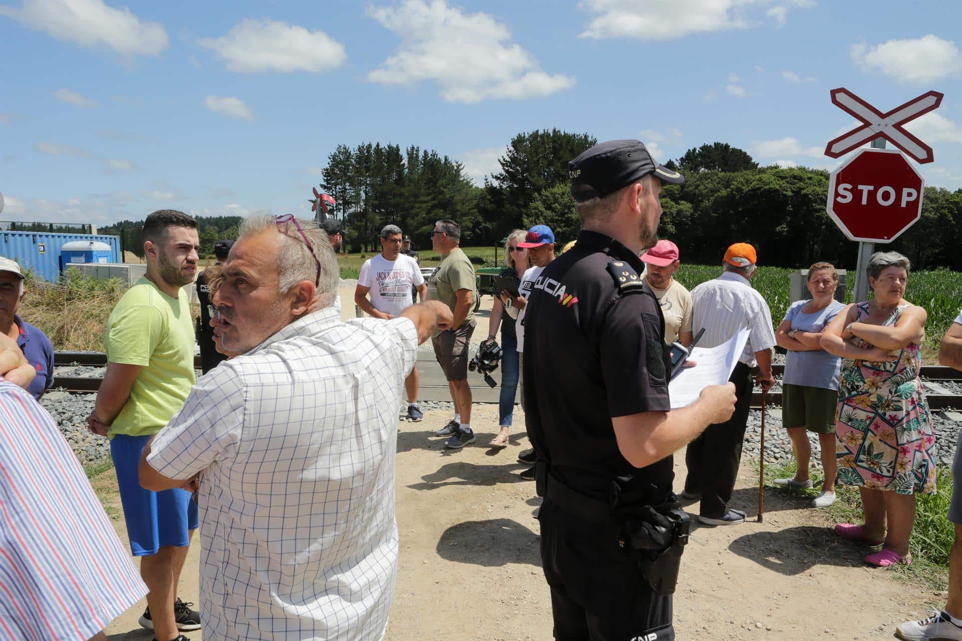 Un agente de Policía Nacional al lado de los vecinos de las parroquias de Coeo y Recimil durante una concentración - Carlos Castro - Europa Press