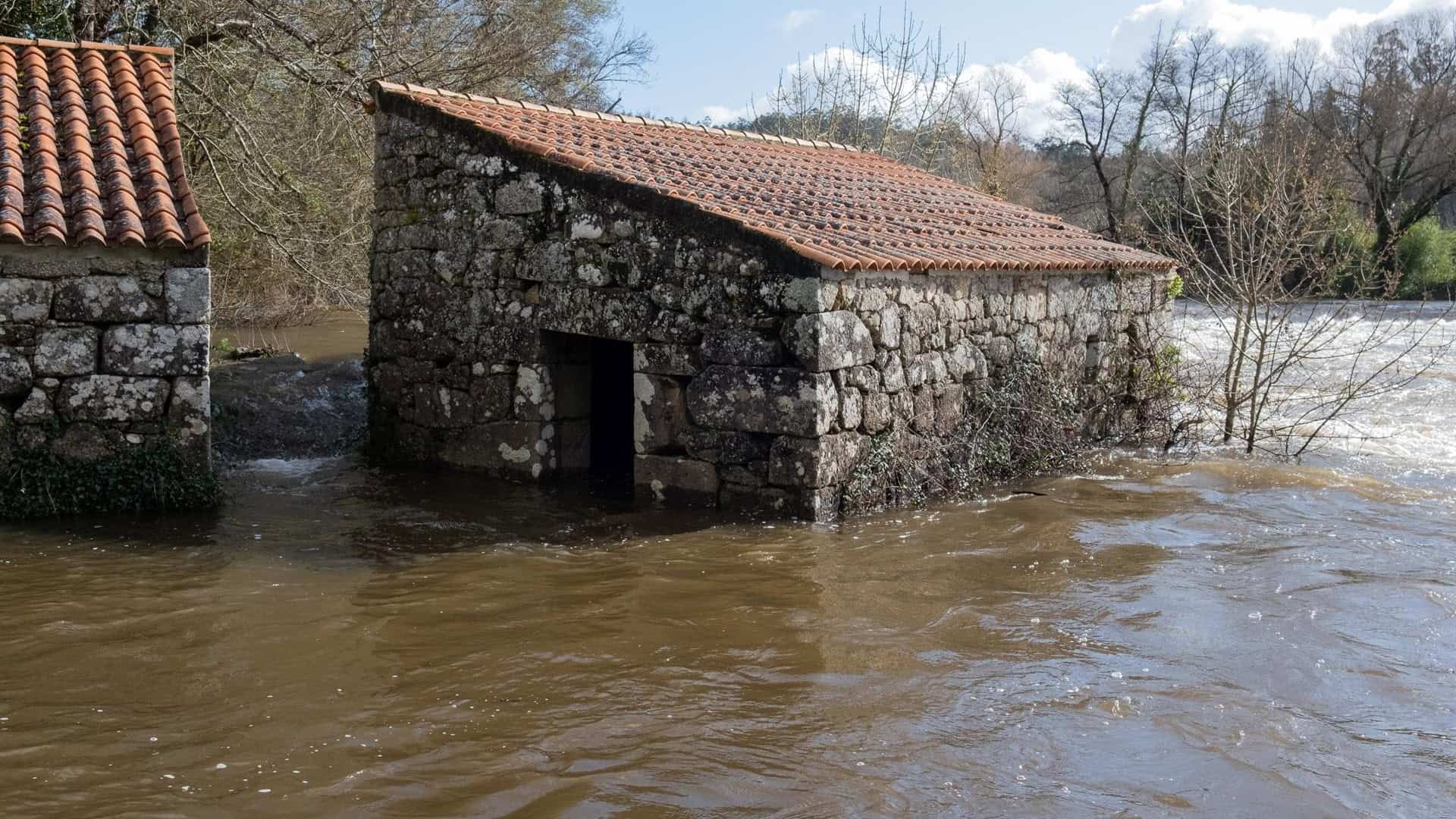 Imagen de archivo del río Tambre desbordado a su paso por Oroso | EP