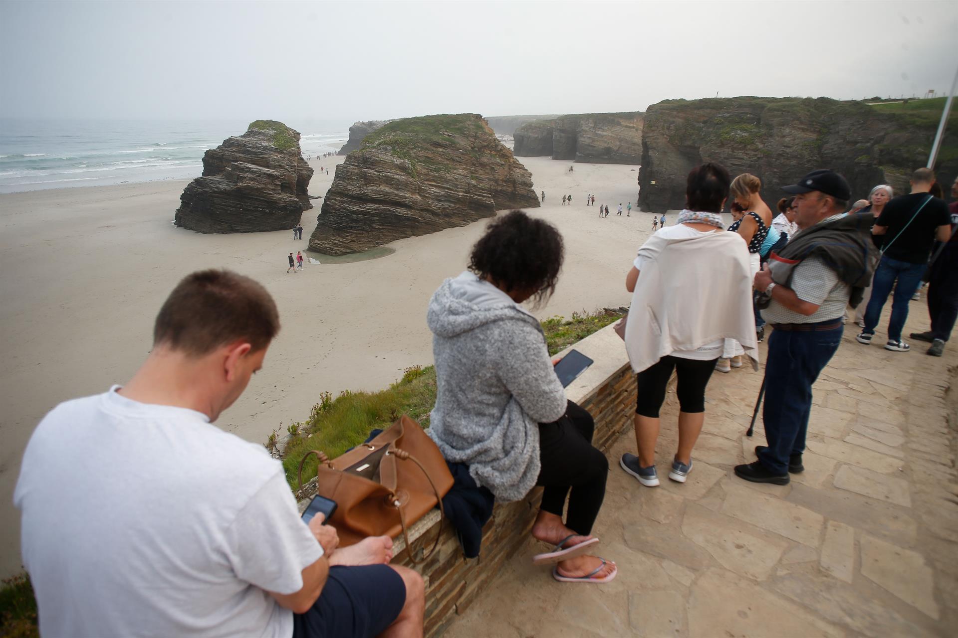 Varias personas pasean durante la bajamar en la playa de As Catedrais | CARLOS DE CASTRO