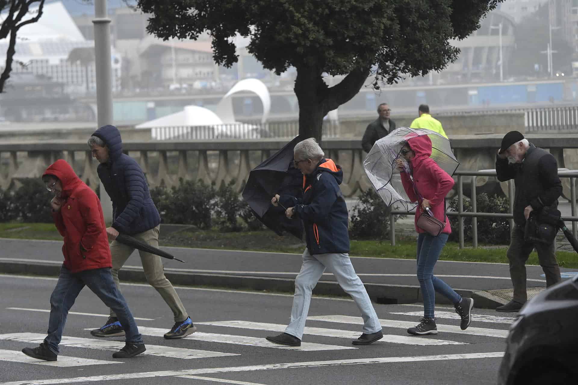 Varias personas se protegen de la lluvia en el Paseo de Riazor, en A Coruña | EUROPA PRESS