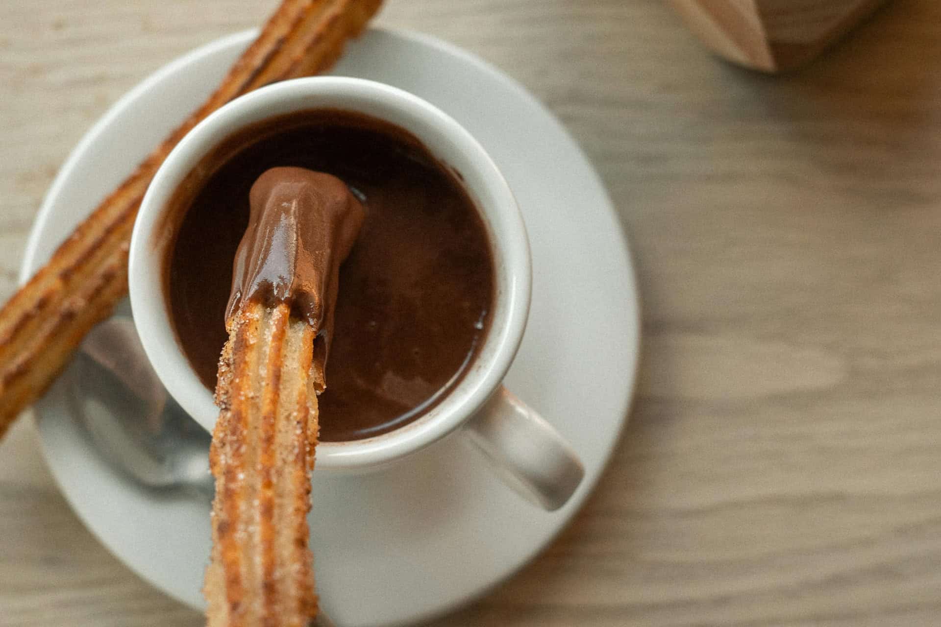 Imagen de archivo de una taza de chocolate con churros | PEXELS