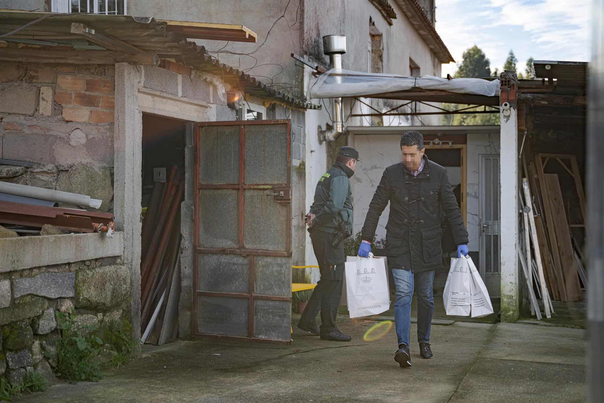 Un agente de la Guardia Civil con bolsas de pruebas de la casa donde una pareja sufrió un violento asalto, en Meis | EUROPA PRESS