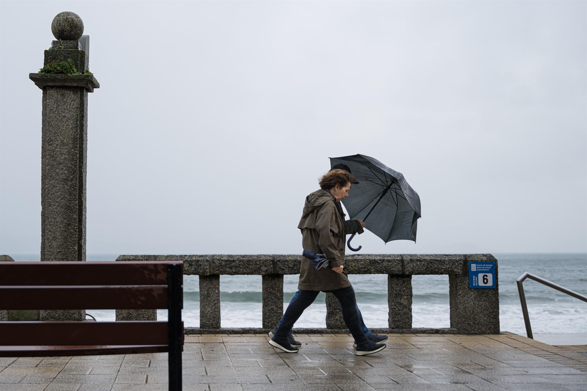 Imagen de archivo de una mujer con paraguas durante una jornada de temporal en la comarca de O Salnés, en Pontevedra | EP