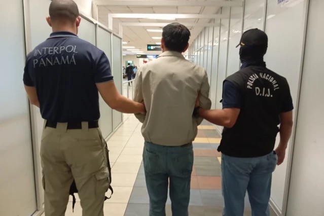 El ciudadano asiático escoltado por un agente de la IInterpol y por otro de la Policía Nacional de Panamá