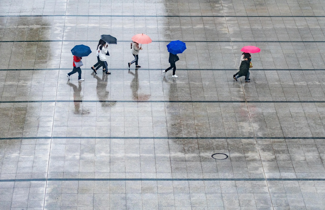 Personas refugiándose con paraguas en un día de lluvia | PIXABAY