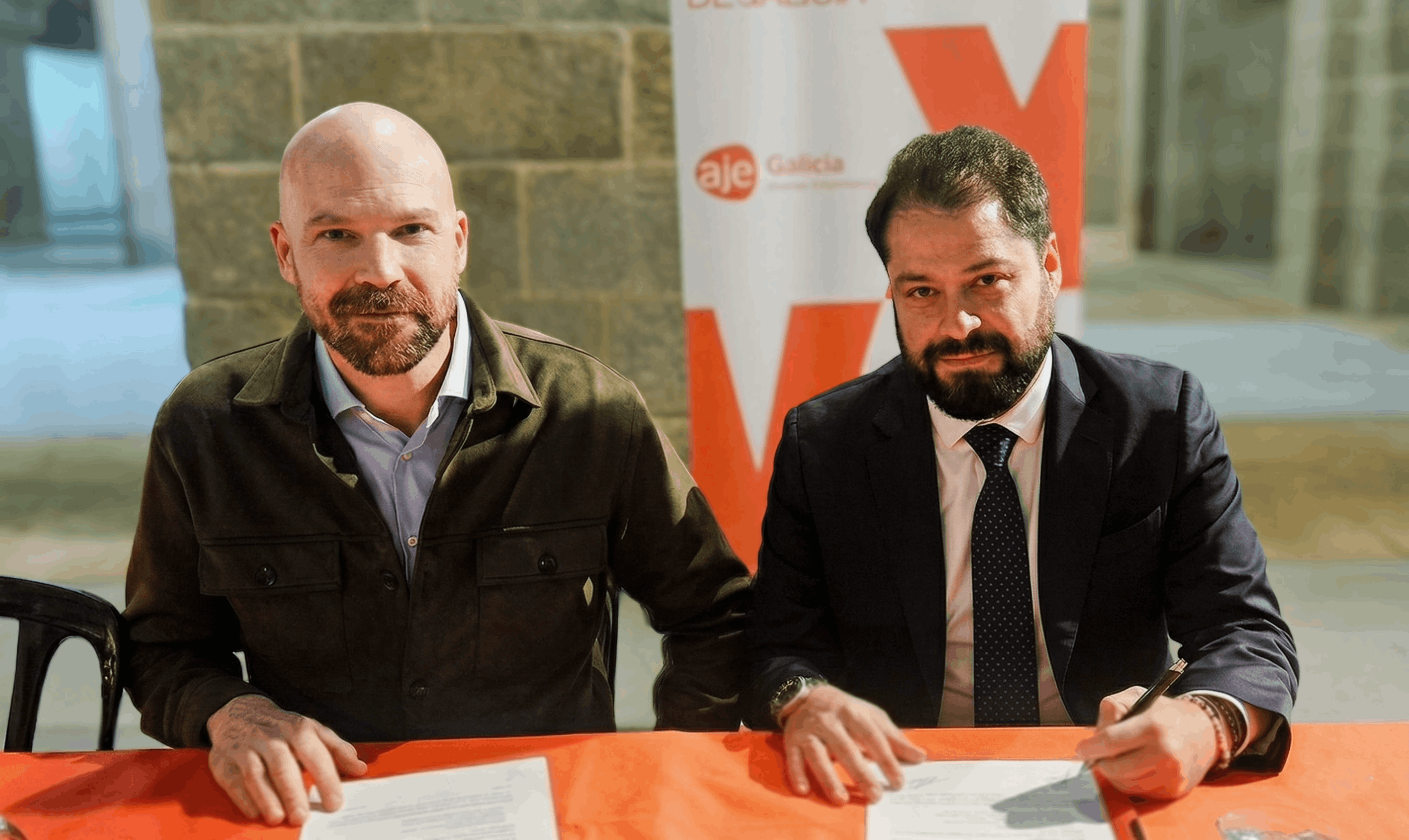 Iago Ebrero, director de enfoques.gal, y Luciano Covelo, presidente de AJE Galicia, durante la firma del convenio.