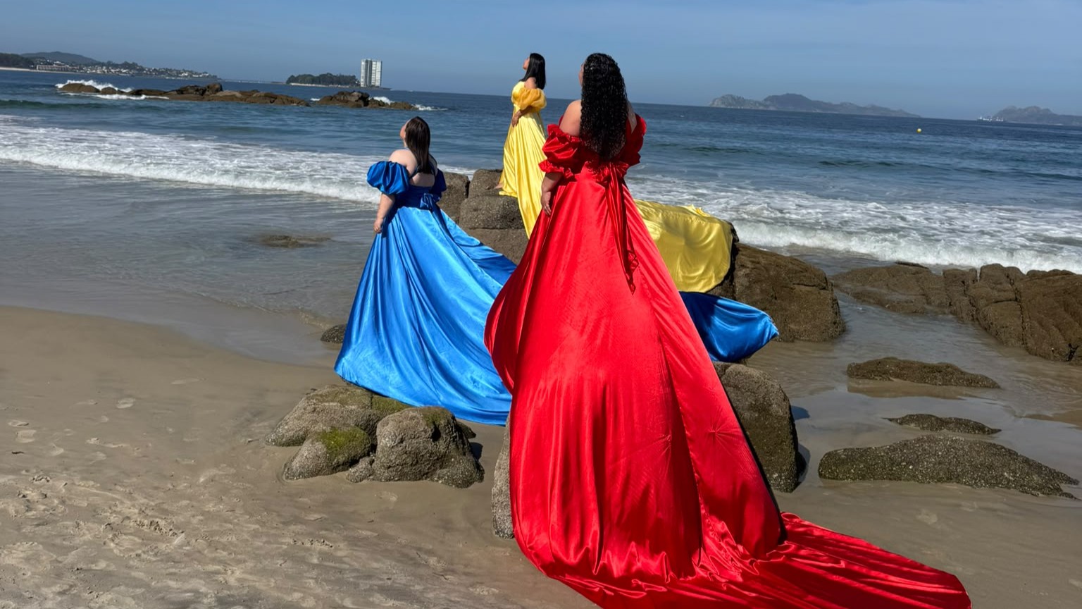 Adriana Caicuto, Andrea Núñez y Magaly Saldarriaga durante la sesión fotográfica en la playa de Samil, representando los colores de la bandera venezolana.