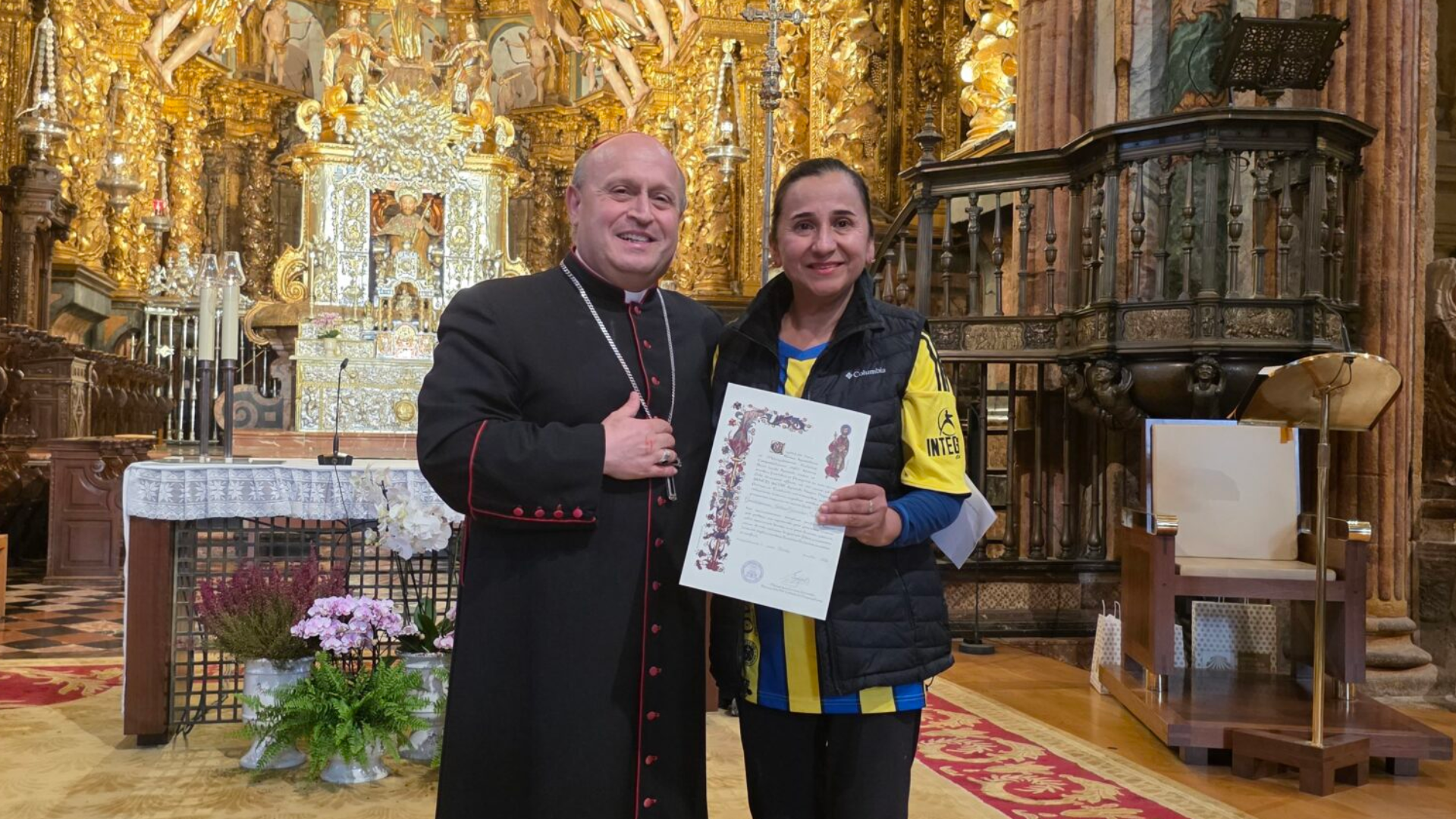 La mexicana  Guadalupe Idalia Goicoechea Salinas, que se convirtió en la Compostela número 500.000 de 2026, junto al arzobispo de Santiago | Catedral de Santiago